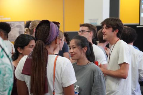 Students mingle in groups at a meet and greet